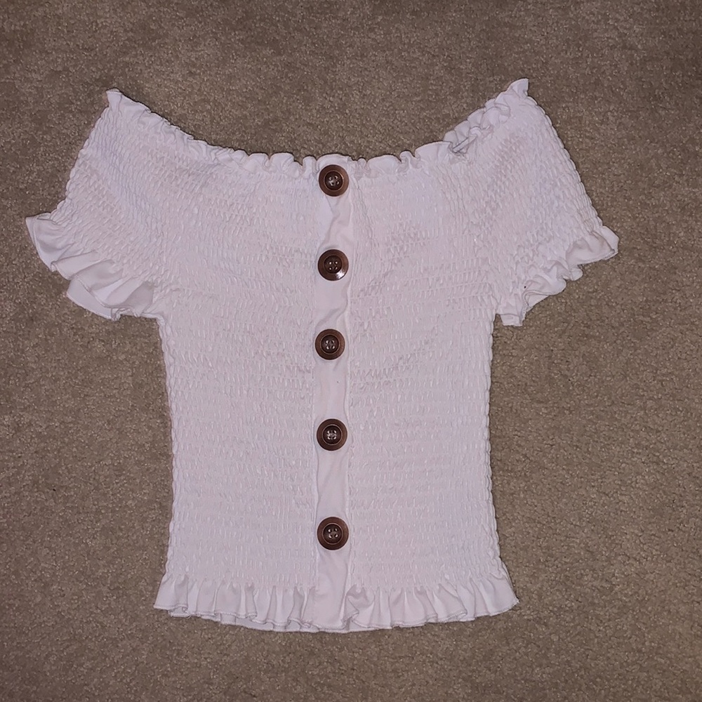 White crop top with buttons going down.